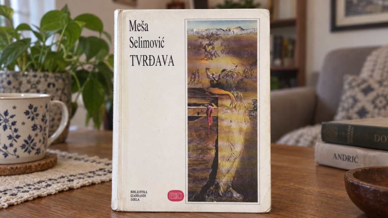 Knjiga „Tvrđava“ Meše Selimovića na drvenom stolu u kućnom ambijentu.